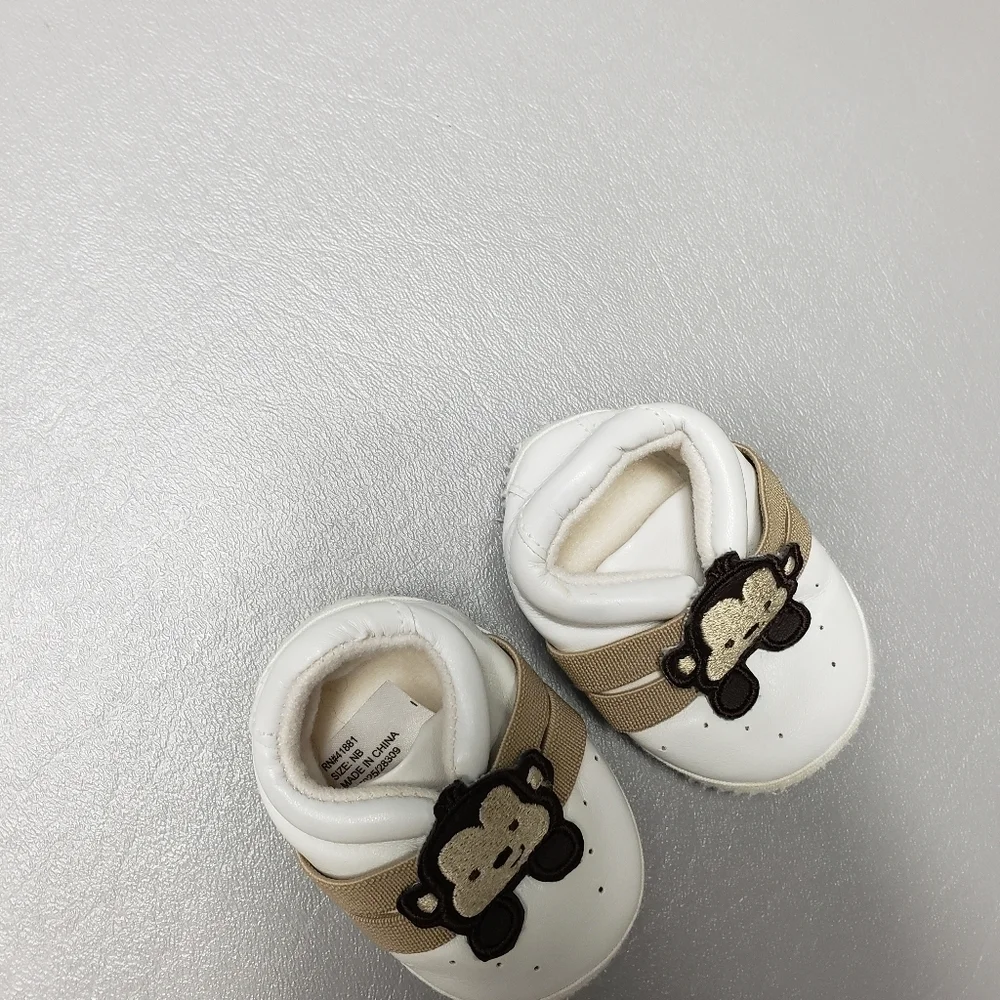 unbranded newborn white and brown gender neutral monkey shoes/slippers